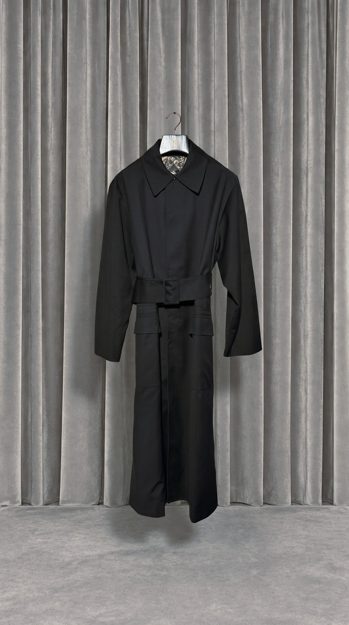 Victor Overcoat Men Black – product on hanger in front of the grey velvet curtain